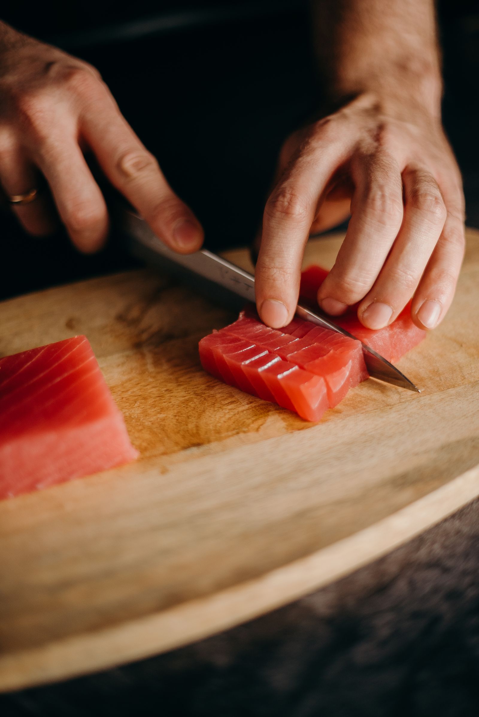 マグロの柵を包丁で切り分ける職人の手元